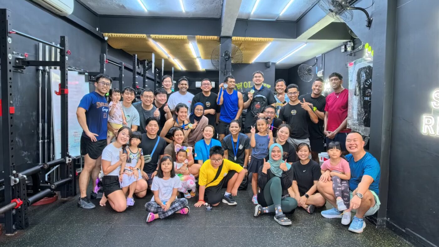 SwoleFit Garage members celebrating together with medals after a monthly fitness challenge